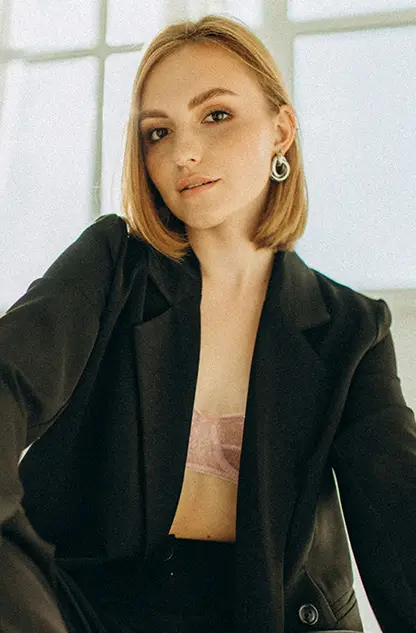 Woman in a black blazer, representing breast procedures